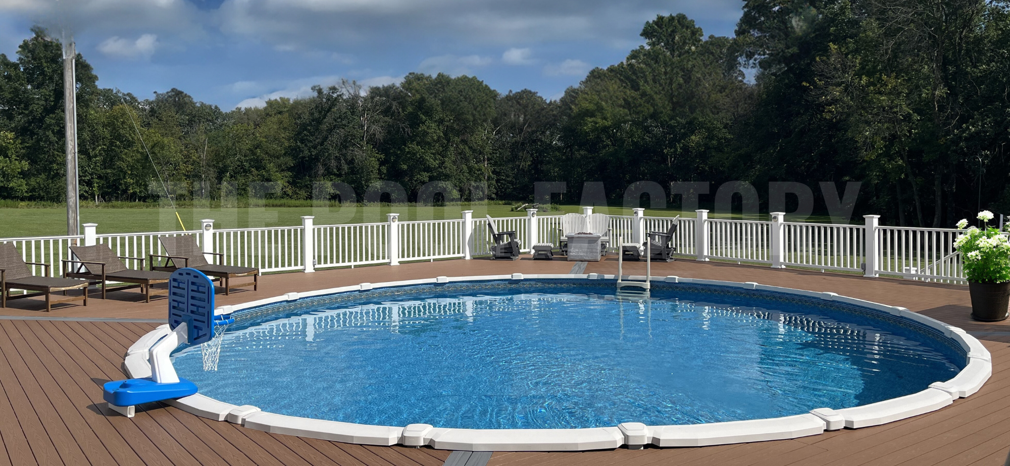 Above ground round swimming pool with wrap around deck and lounge chairs