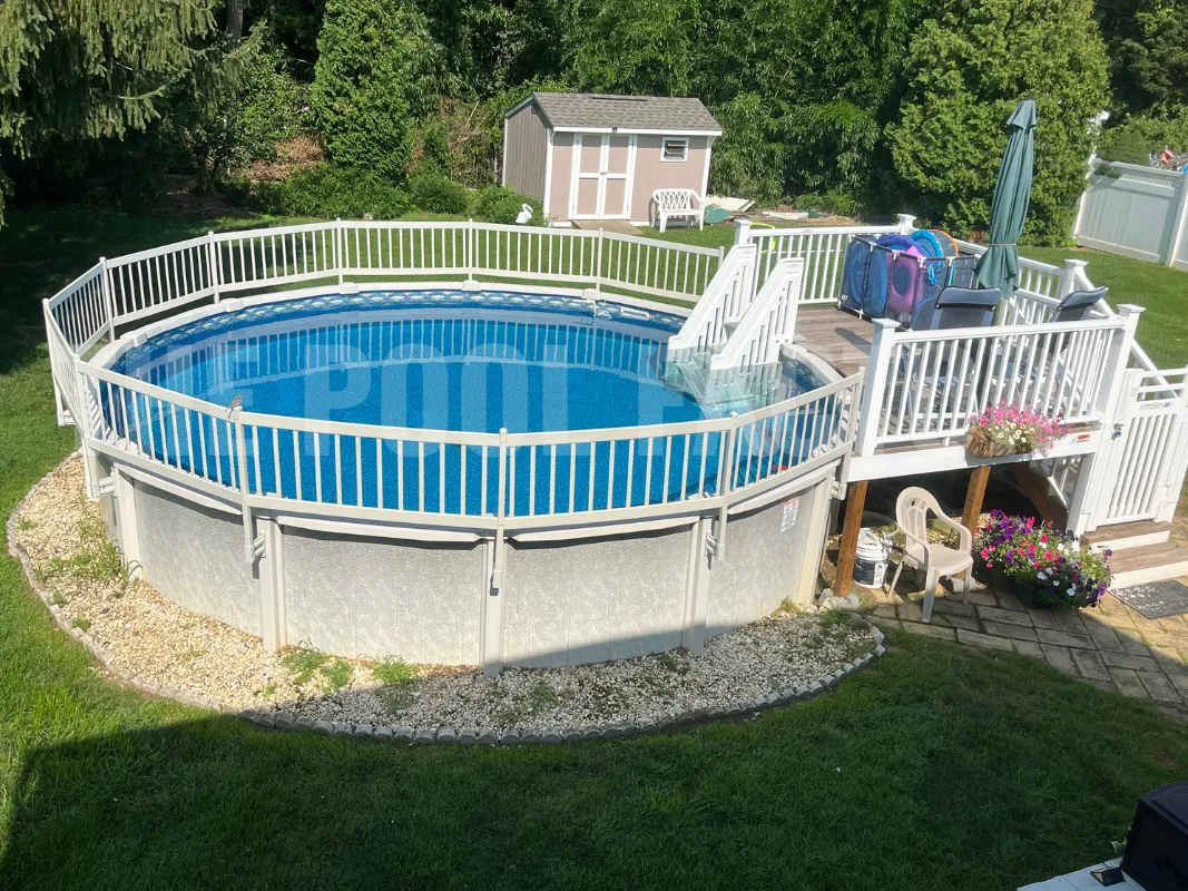 Backyard entertaining space with round saltwater pool, deck, and safety fence
