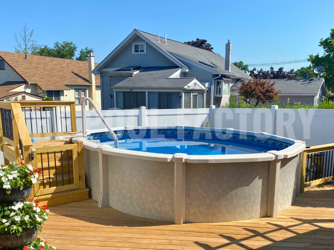 Oval saltwater swimming pool with wooden deck and vinyl fence