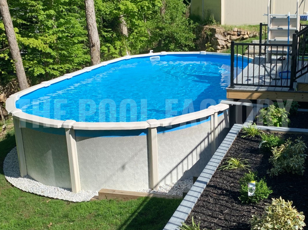 Oval saltwater pool surrounded by trees, decorative rocks, and forest landscape