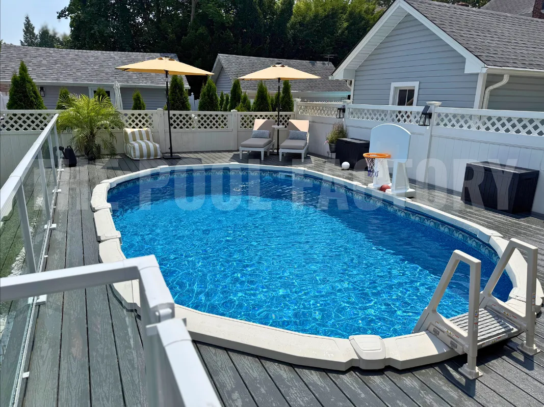 Oval above ground saltwater pool with Trex deck and lounge chairs in backyard
