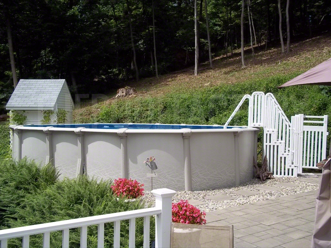 Above ground oval saltwater swimming pool with surrounding stone walkway