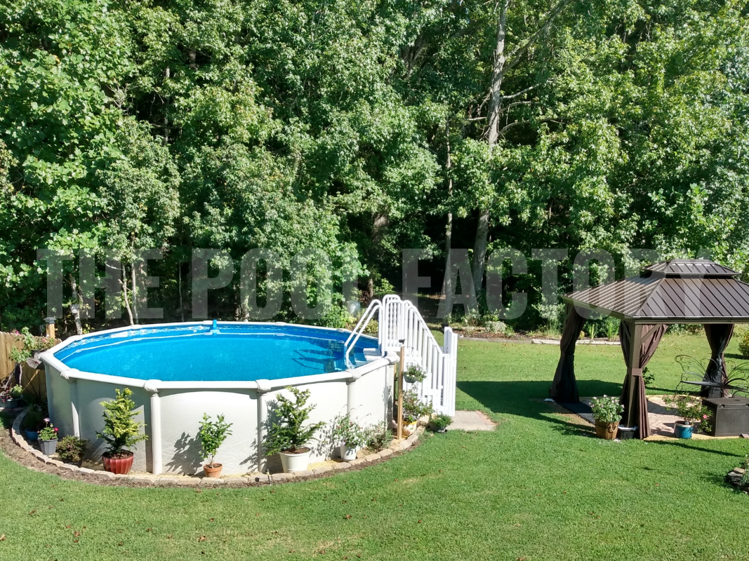 Round saltwater swimming pool with plants, gazebo with comfy seating and forest backdrop on a sunny day