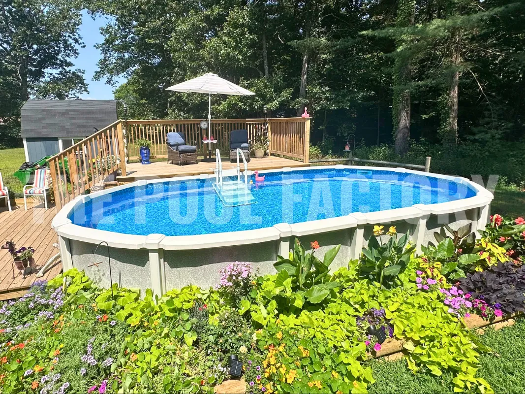 Oval above ground saltwater pool with partial deck and lush garden shrubbery