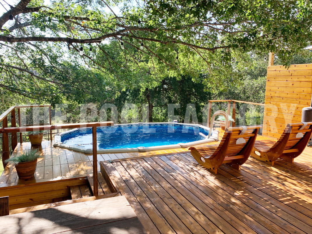 Above ground oval pool with deck, wooden lounge chairs and forest views 