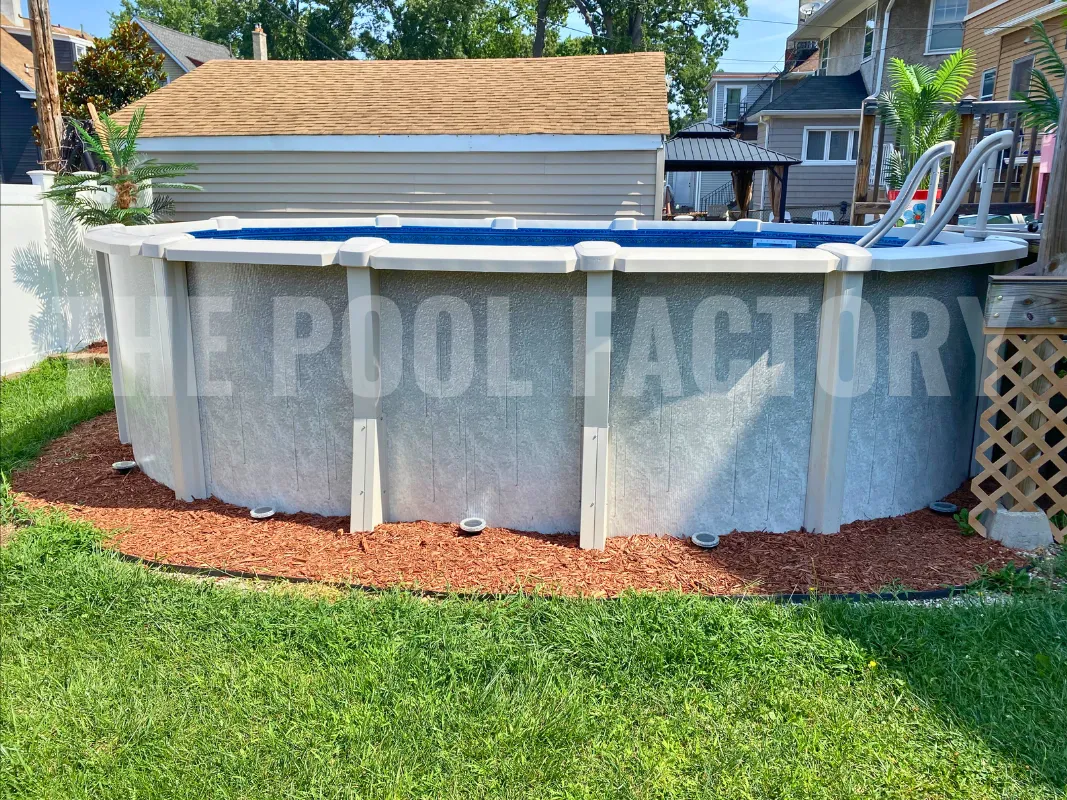 Above ground oval saltwater pool with landscaped edges and green lawn