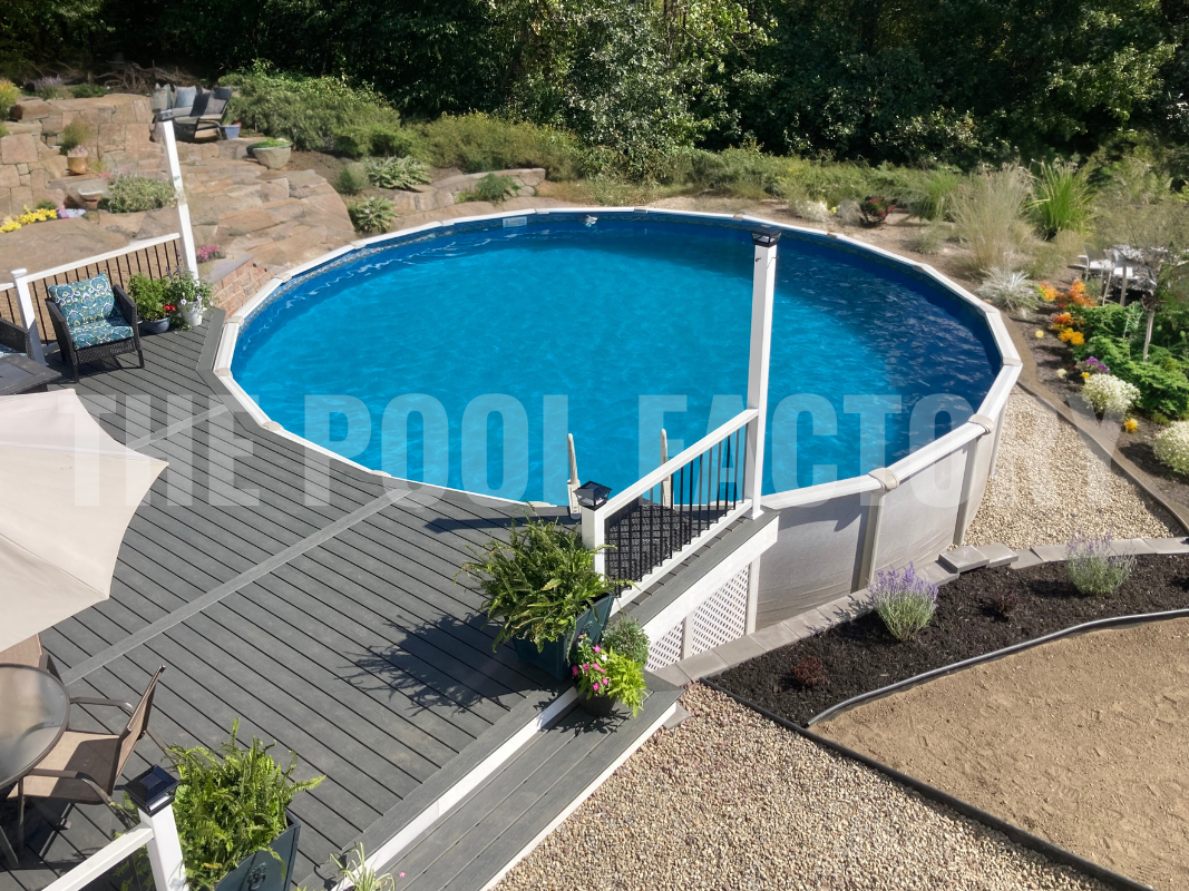 Above ground round swimming pool with deck, garden bed and stone work with seating