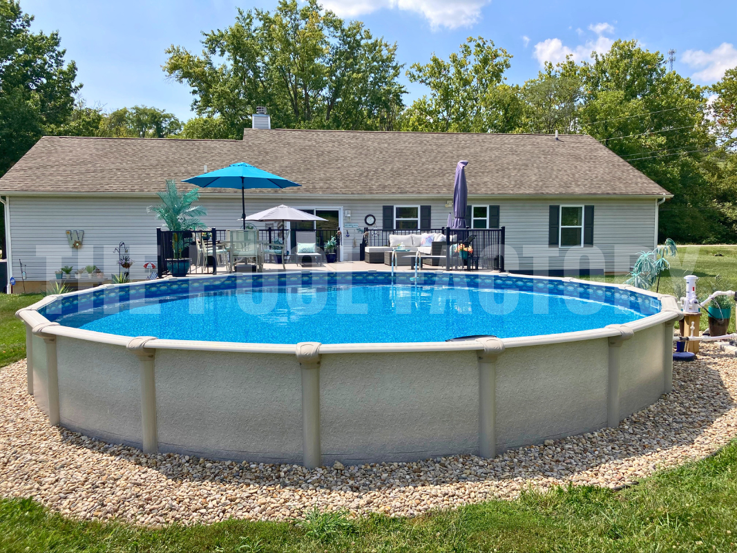 Above ground swimming pool with decorative rocks and partial deck with chairs