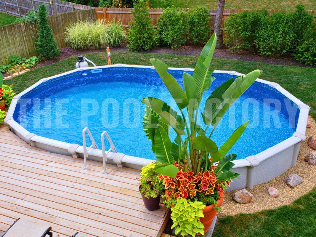 Oval semi-inground swimming pool with deck platform and shrubs surrounding 