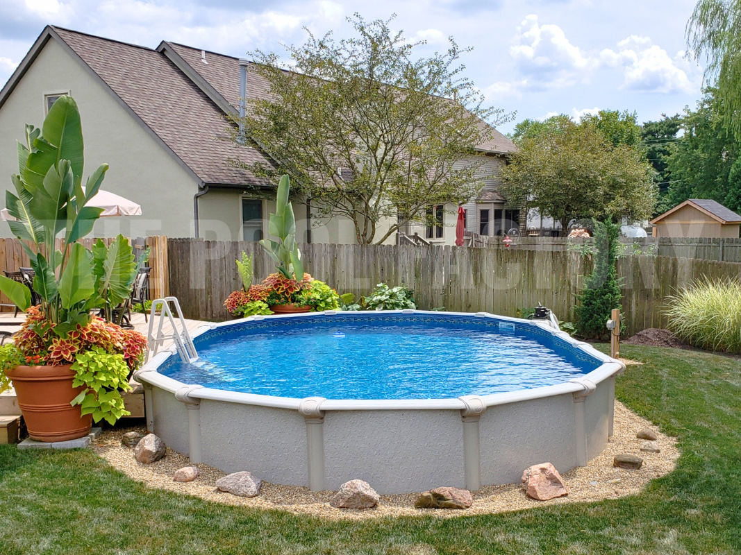 Oval semi inground pool with exotic plants and flowers