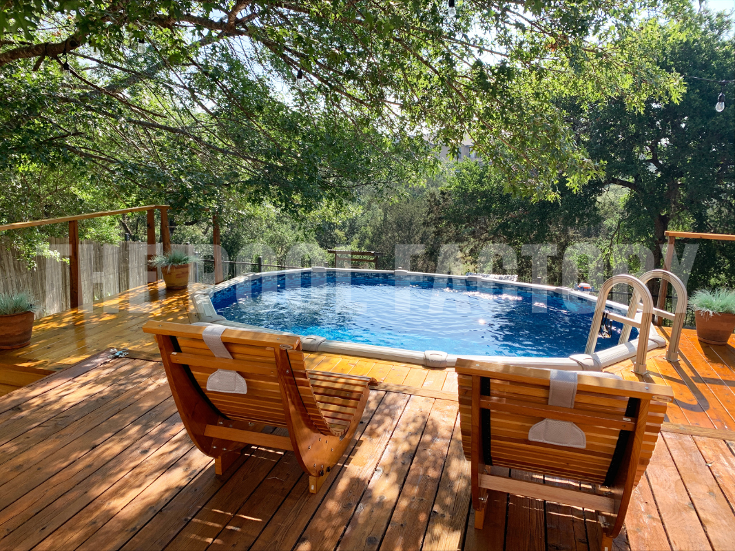 Oval above ground swimming pool with a cozy deck area and gorgeous forest views