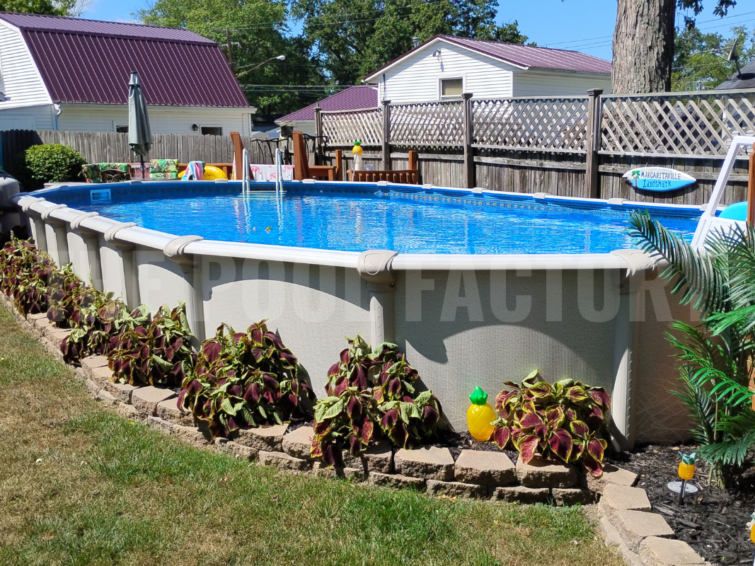 Backyard with an oval semi-inground pool with lush plants and a privacy fence