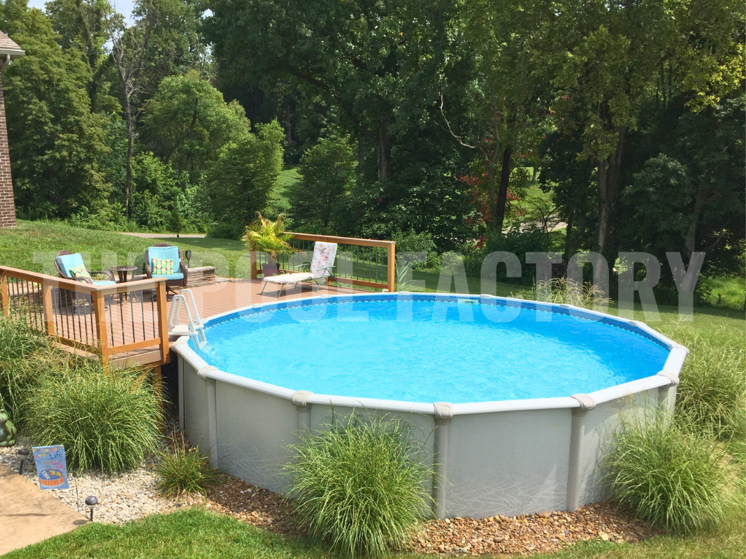 Above ground round saltwater pool with partial deck and shrubs and greenery surrounding