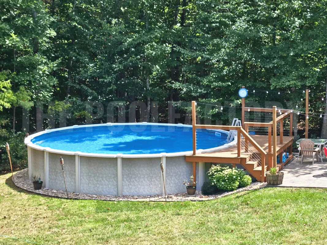 Round above ground saltwater swimming pool with wood deck and green grass