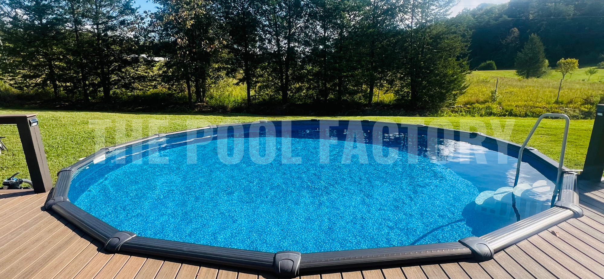 Round above ground swimming pool with forest view, deck, and sunny landscaping