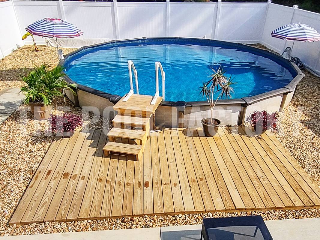 Round above ground swimming pool with decorative rocks and platform deck access
