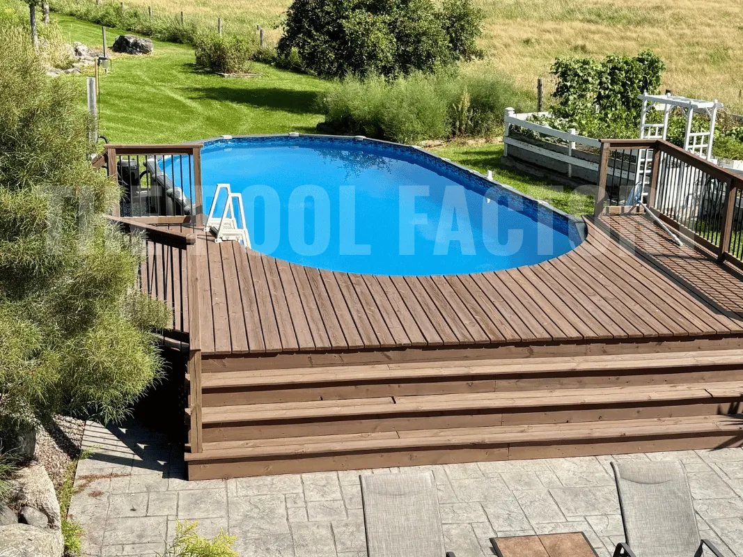 Oval above ground pool with deck extension and scenic backdrop