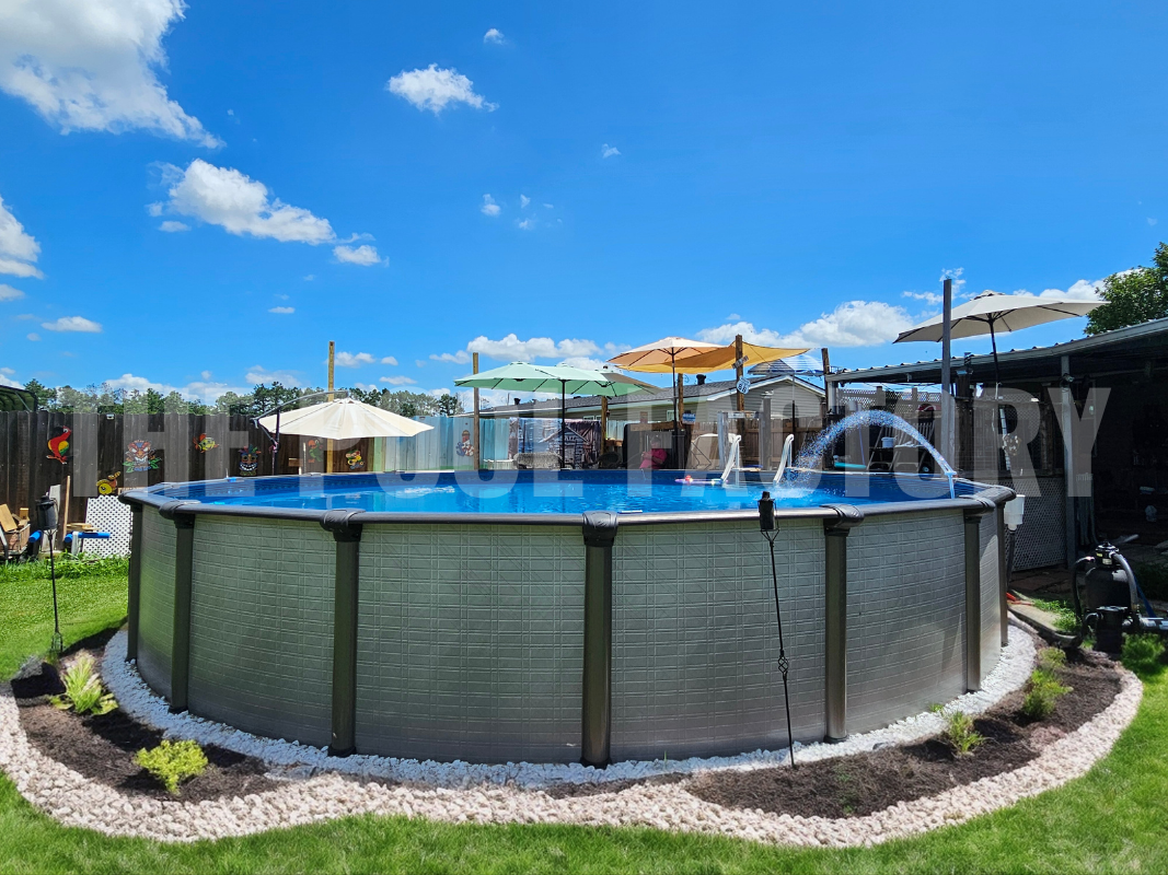 Backyard with round swimming pool, shrubs and mulch with decorative rocks