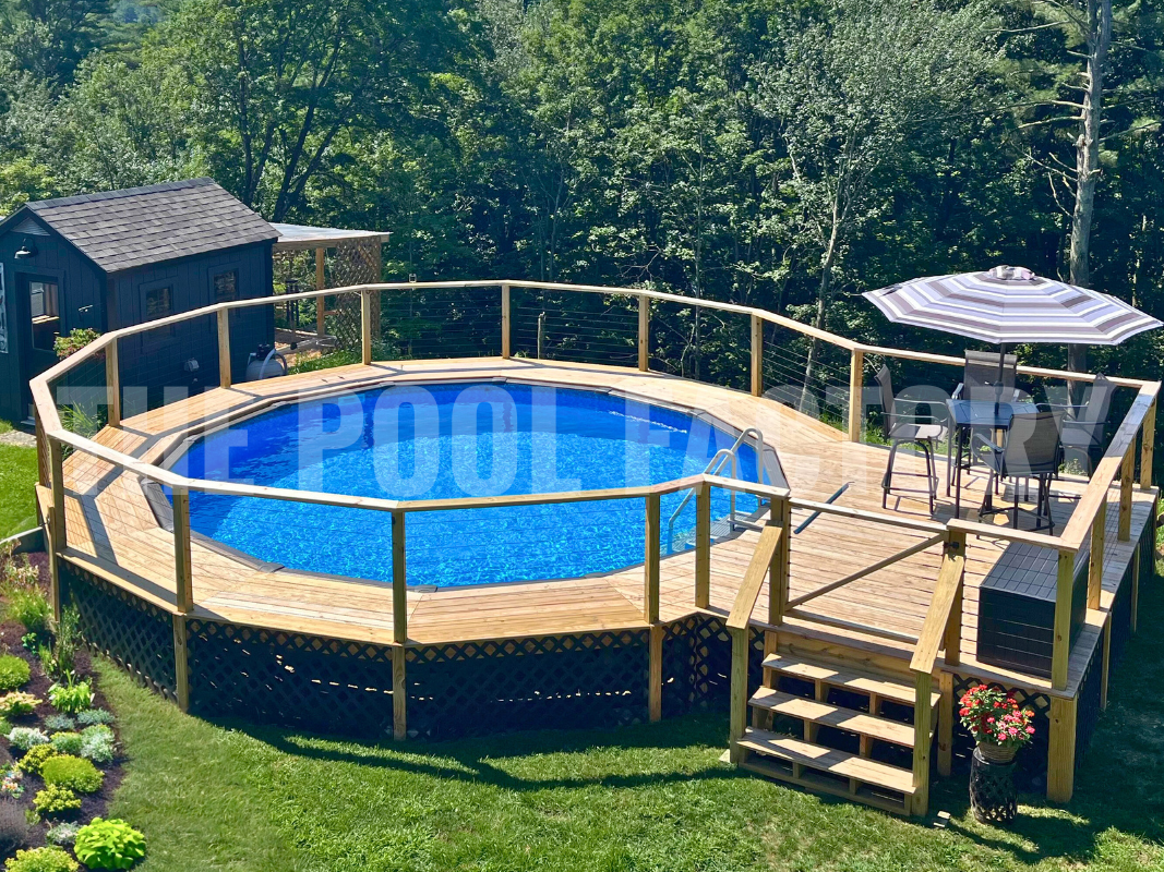 Round swimming pool with steps leading to a sunny deck, surrounded by trees