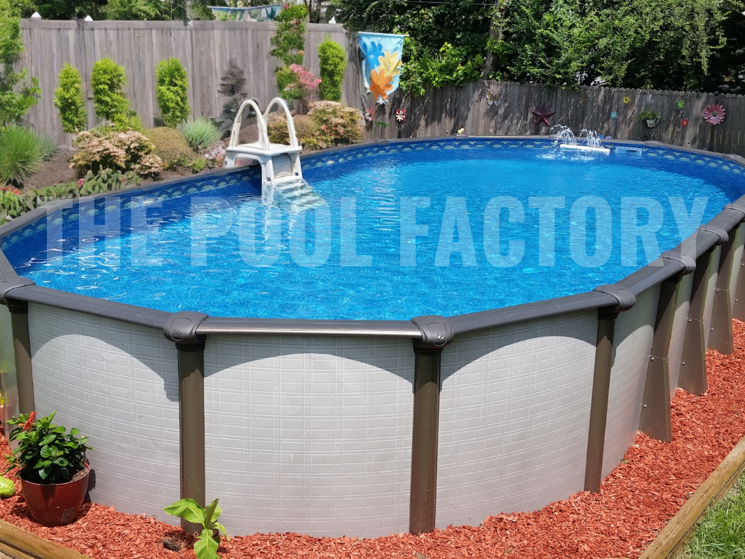 Above ground pool with oval shape, decorative mulch, and sunlit plants