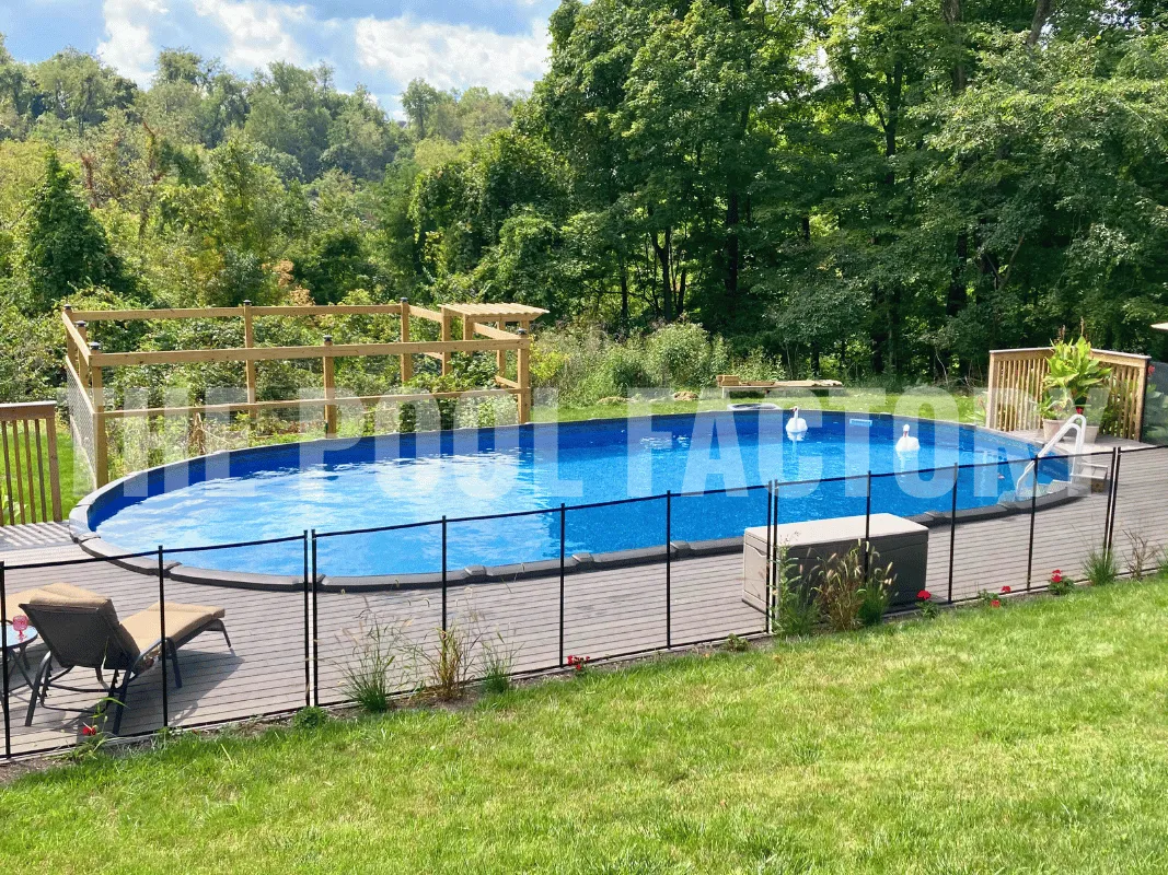 Oval semi-inground pool with fenced-in backyard and partial deck area