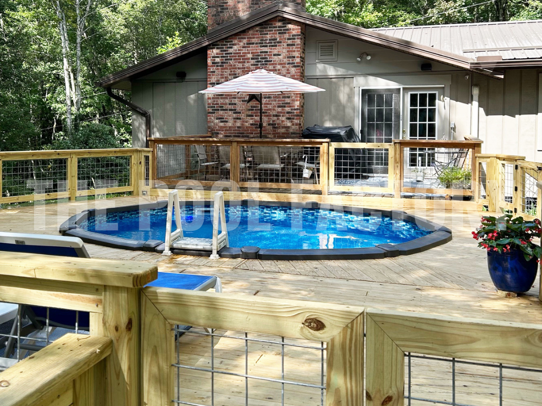 Oval swimming pool surrounded by full deck on a sunny day