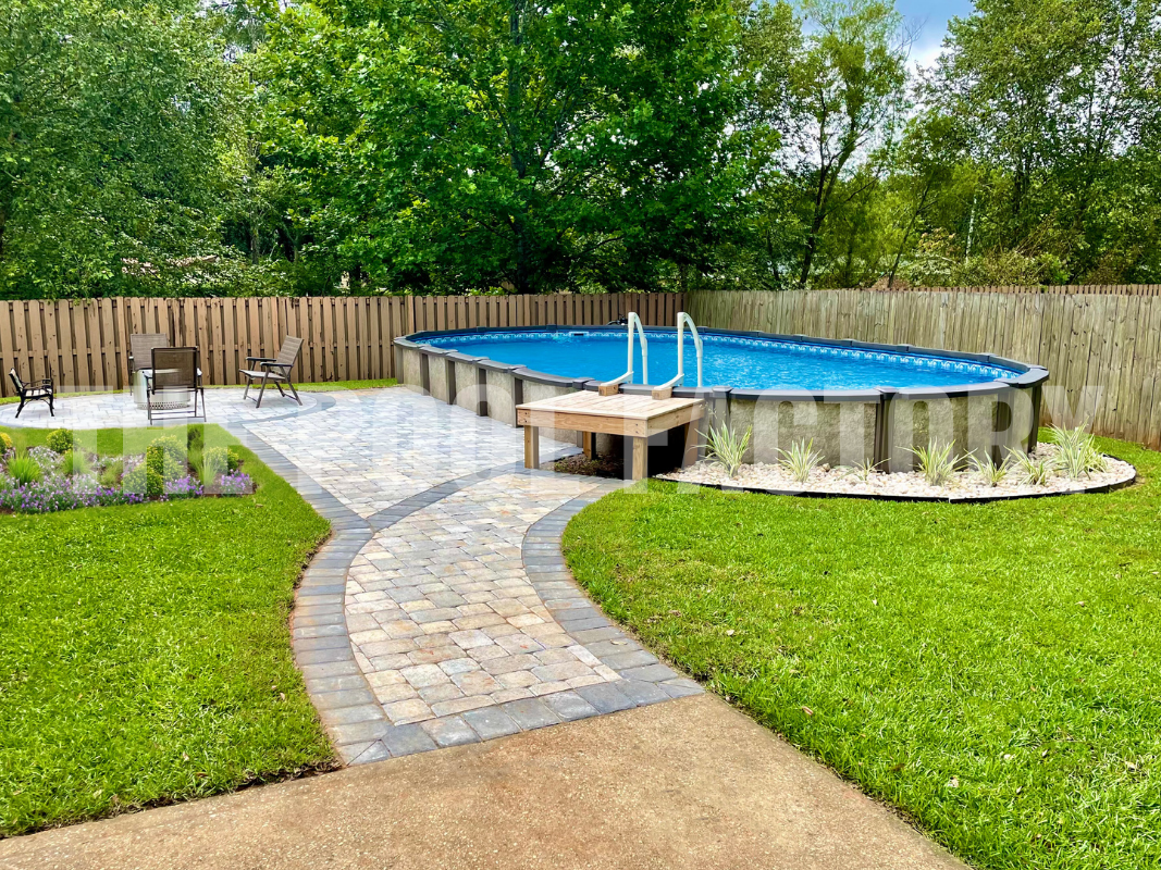 Saltwater oval swimming pool with stone patio and green landscaping