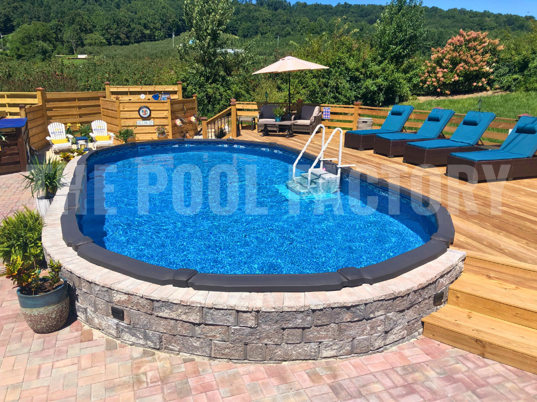 Oval above ground pool with partial deck and stone patio on a sunny day