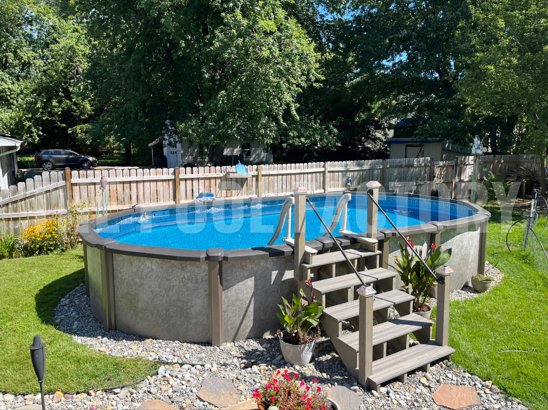 Above ground oval swimming pool with wooden steps, and decorative rocks