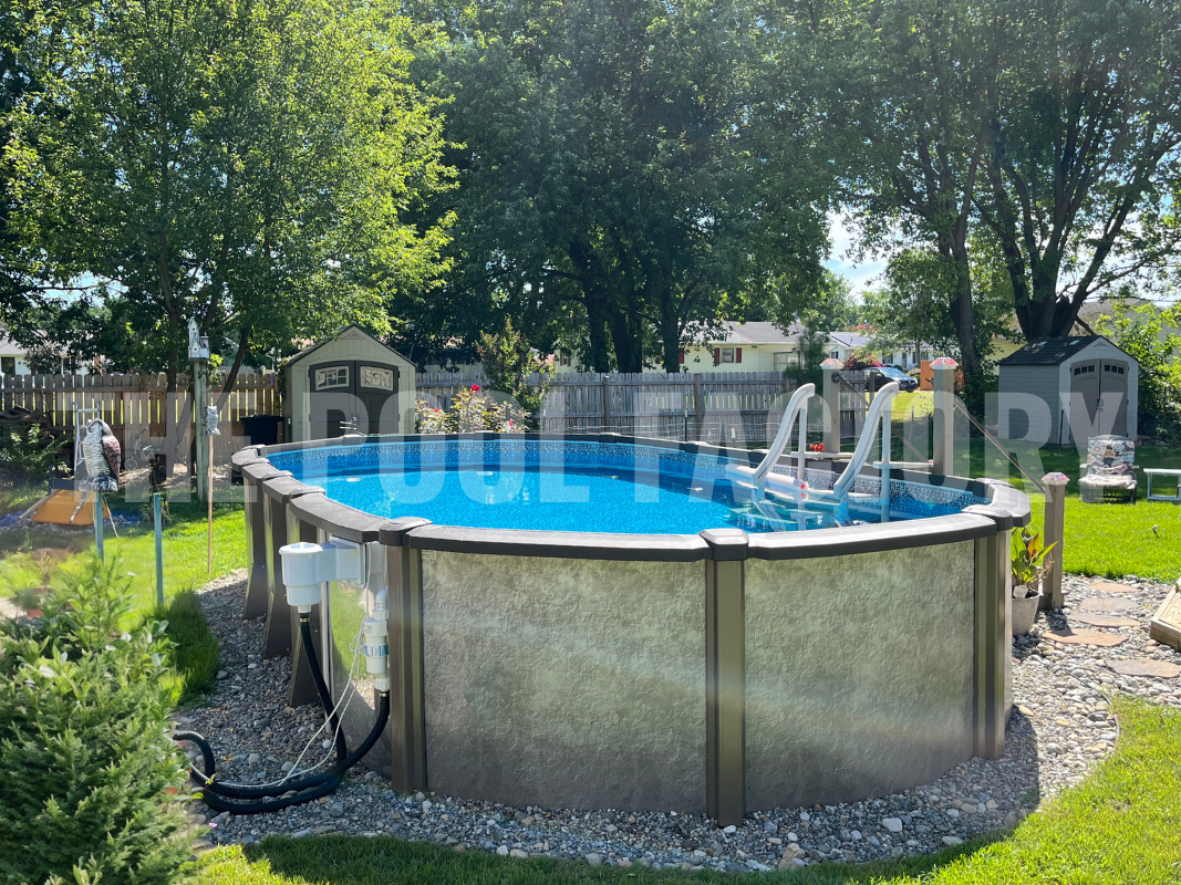 Above ground oval swimming pool with decorative rocks and privacy fence