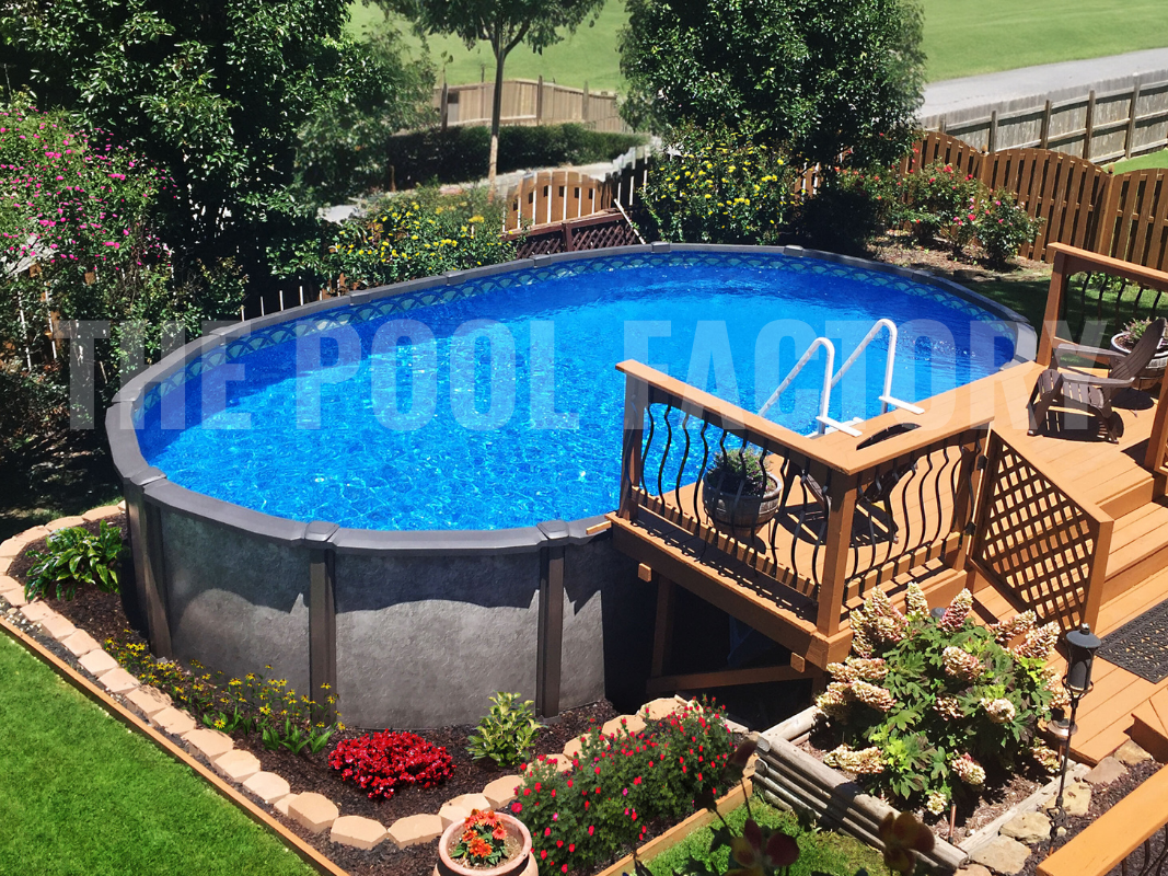 Saltwater above ground oval swimming pool with partial deck, colorful flowers and tall shrubs
