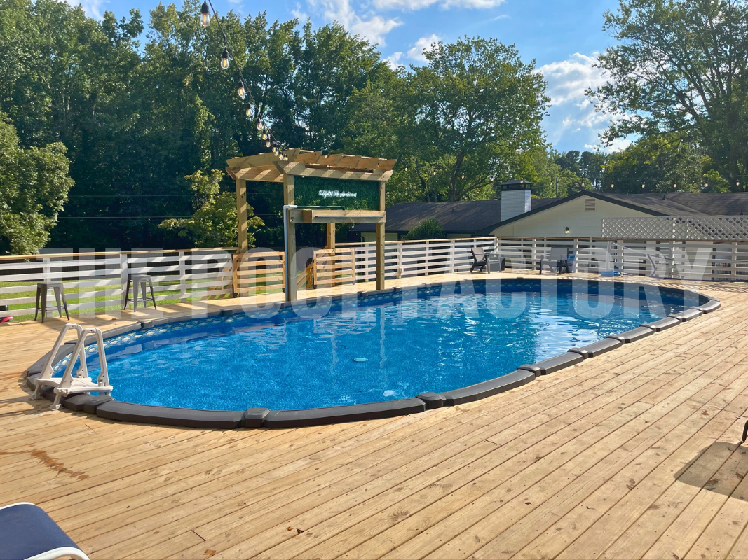 Oval saltwater swimming pool with full deck, surrounded by trees and greenery