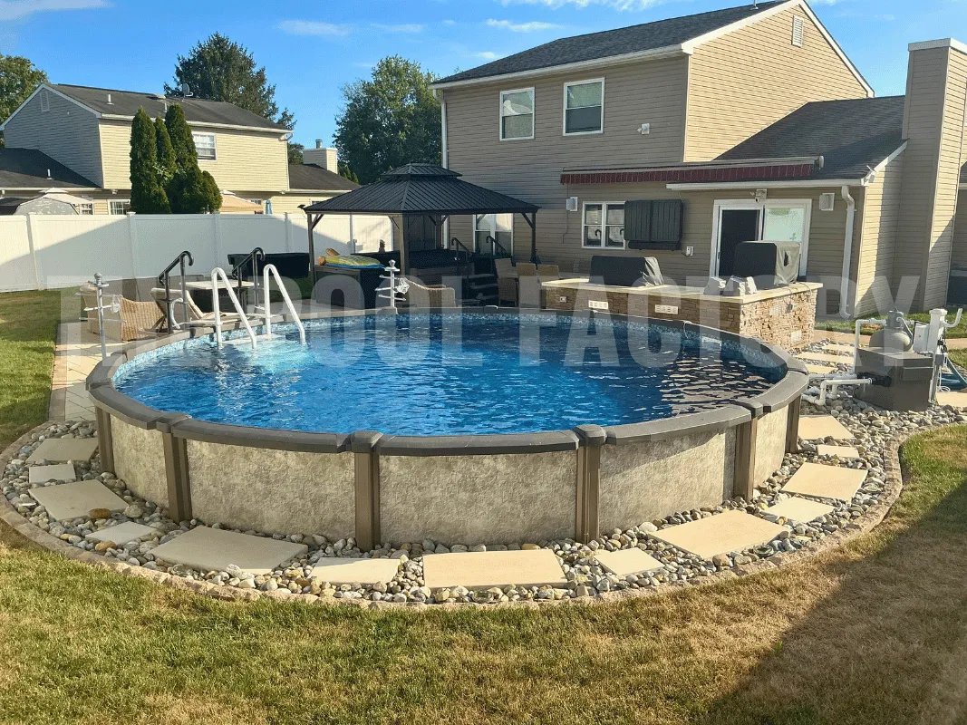 Round semi-inground swimming pool with natural stone border, grass, and bright sunshine
