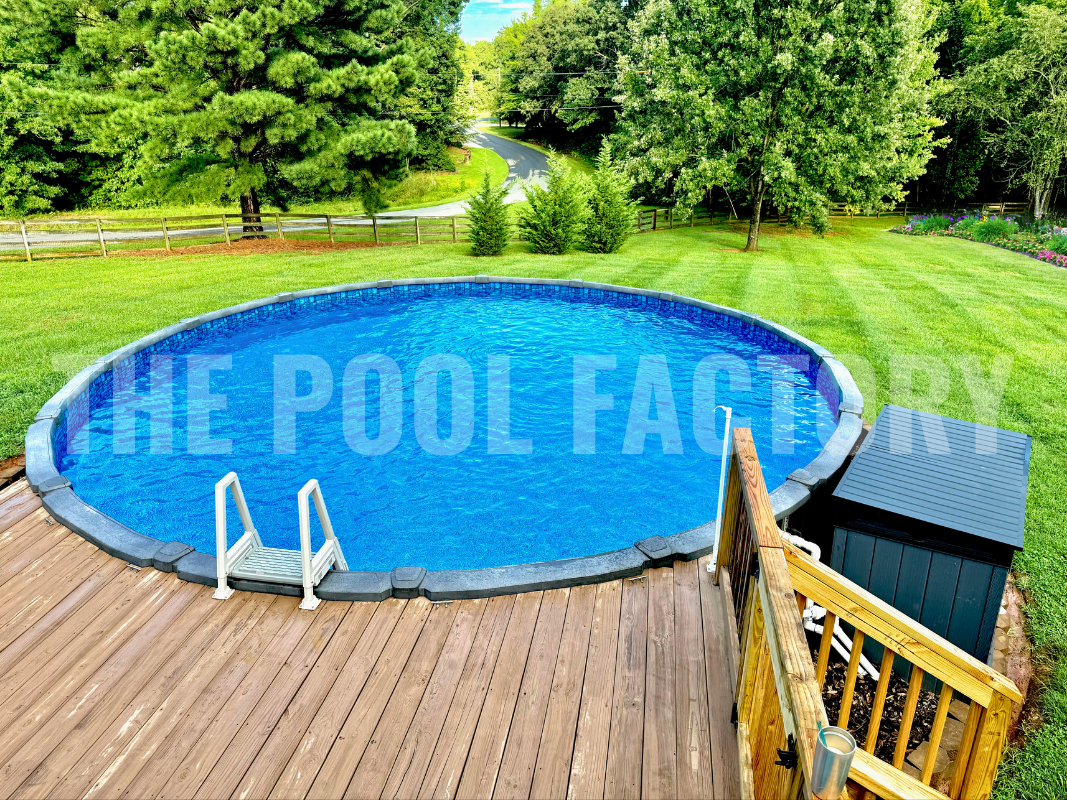 Above ground saltwater round pool with partial deck, tall trees and garden backdrop