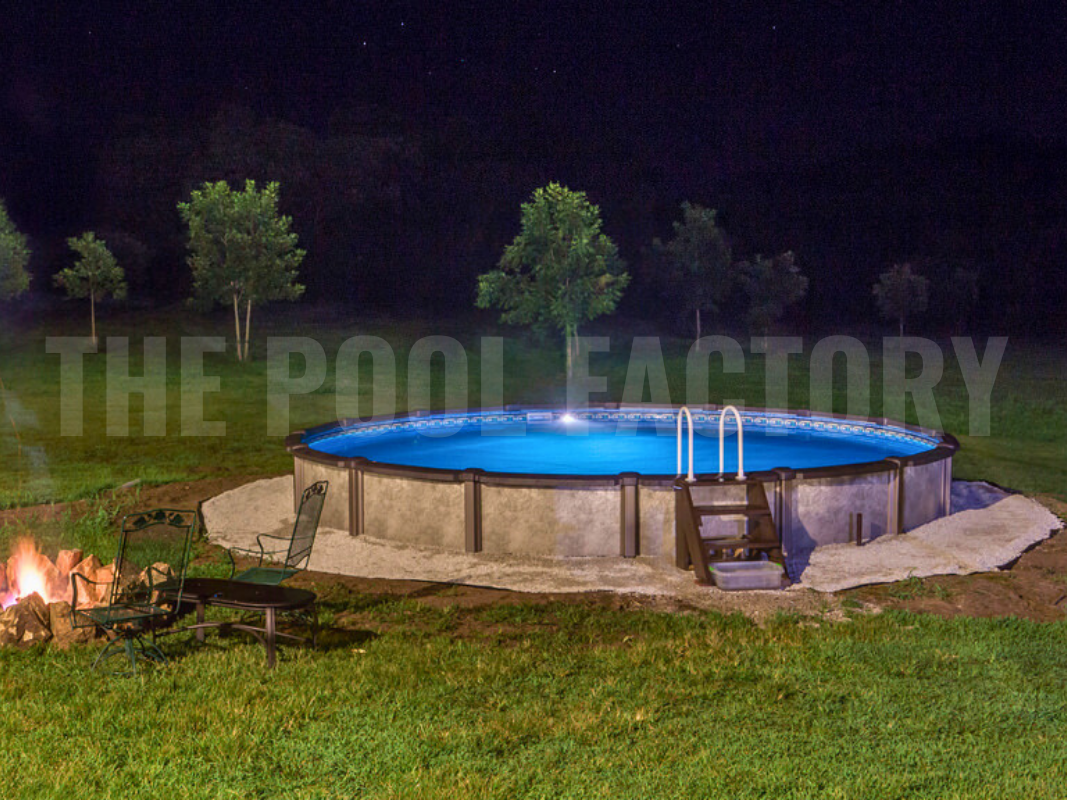 Backyard round swimming pool with forest landscape, lights, fire pit and greenery at night