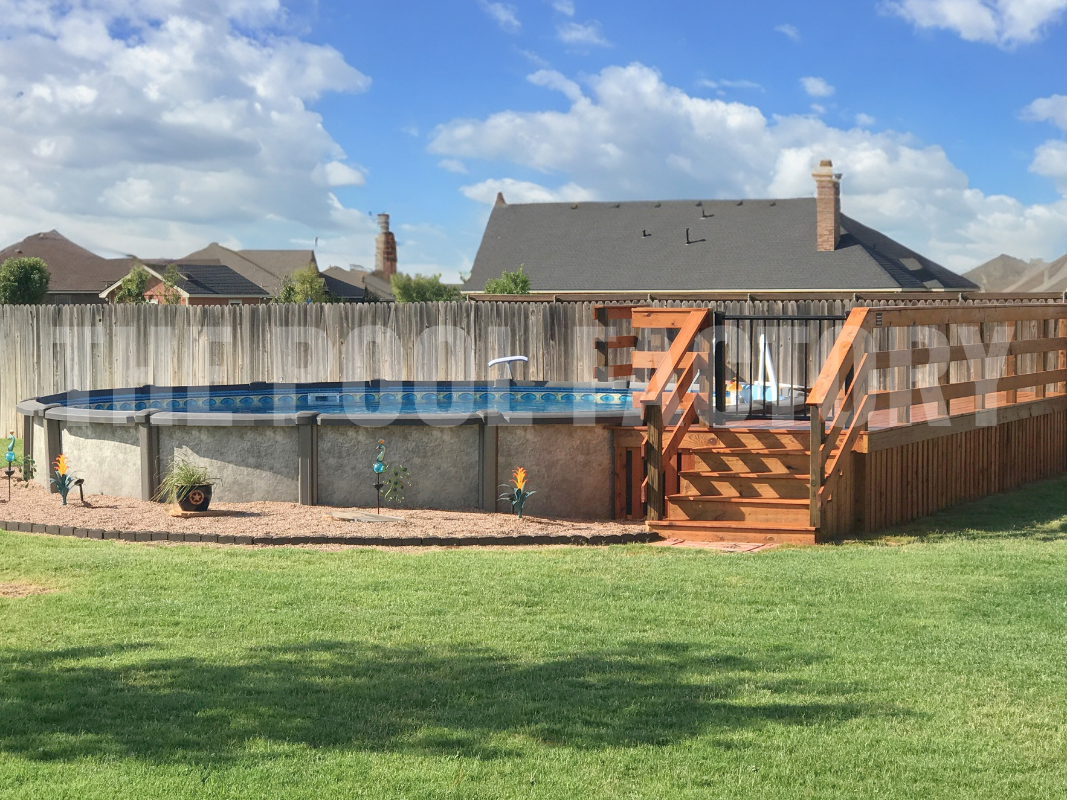 Round swimming pool with partial deck and a wooden privacy fence