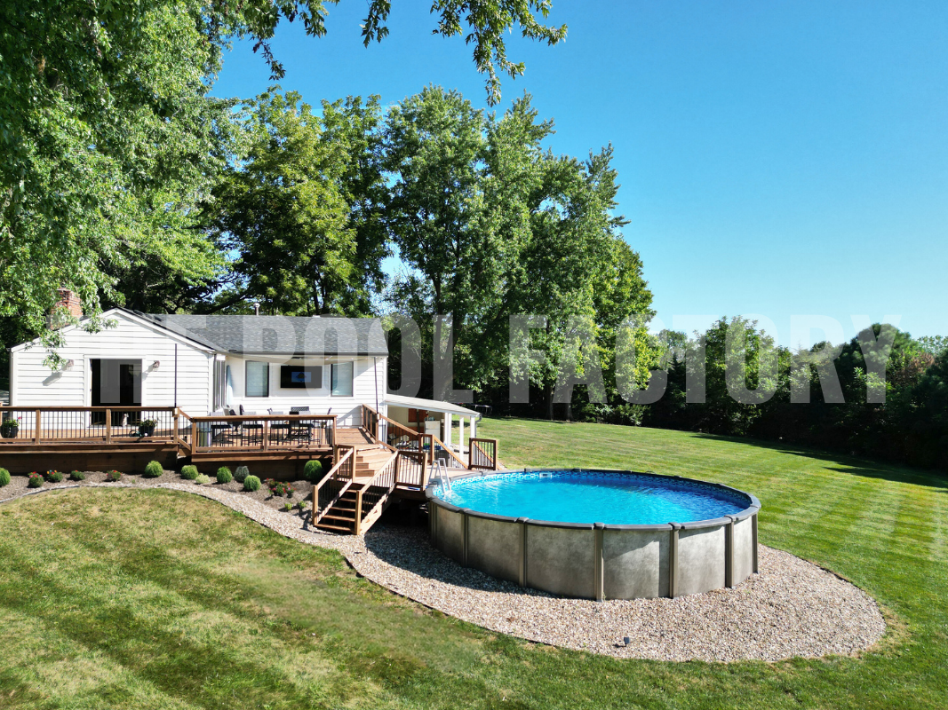 Above ground swimming pool with decorative rocks and surrounding greenery