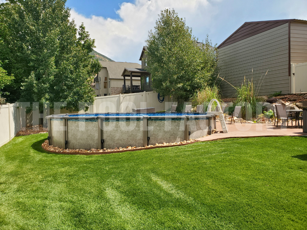 Above ground saltwater pool with decorative rocks and concrete patio