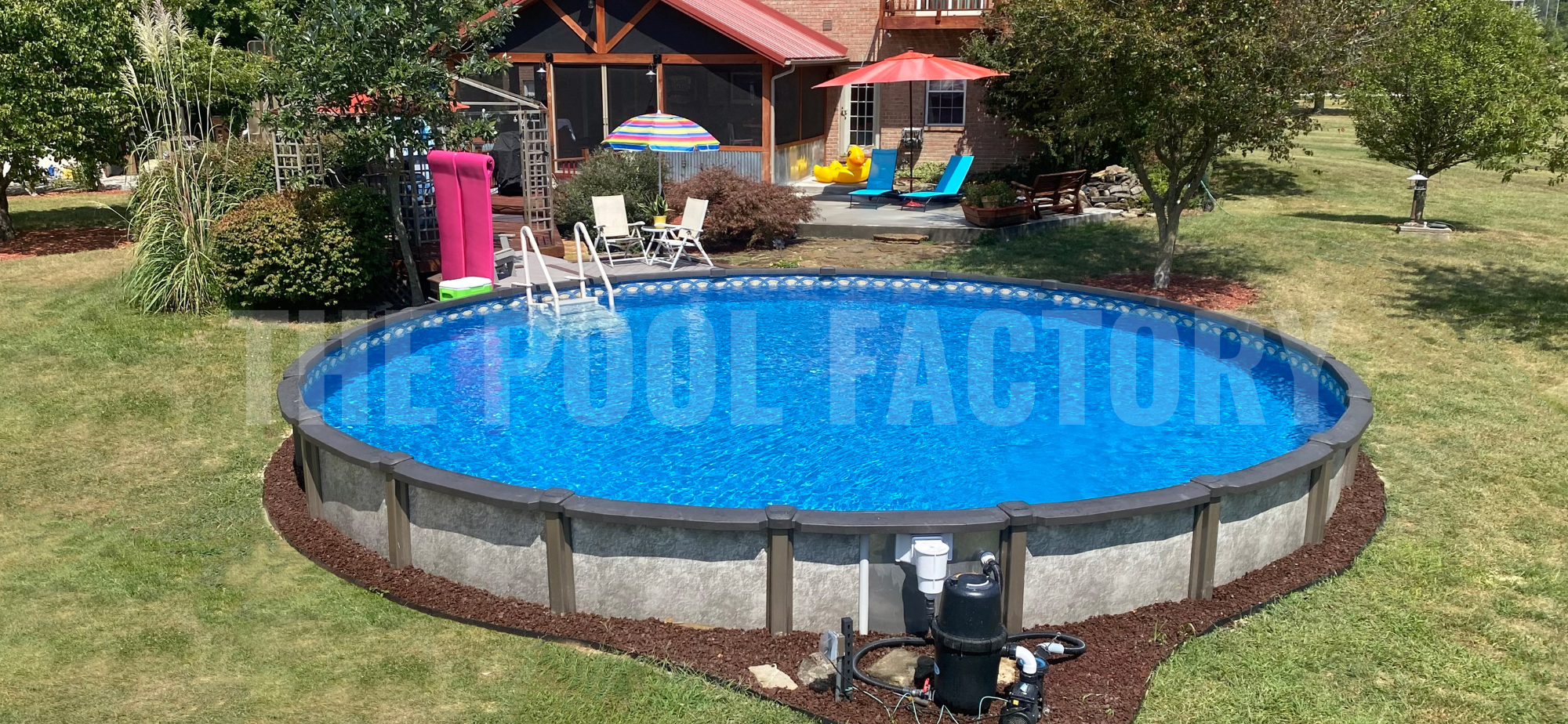 Above ground swimming pool with decorative mulch on a sunny day