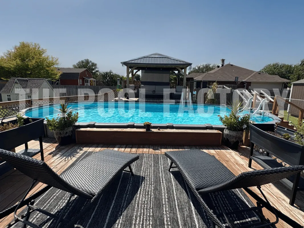 Oval semi-inground pool with raised composite deck, loungers, and potted plants in landscaped yard