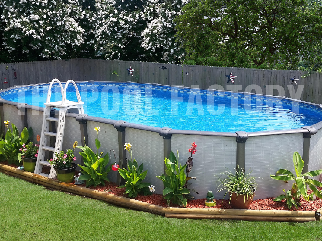 Oval above ground swimming pool surrounded by colorful plants