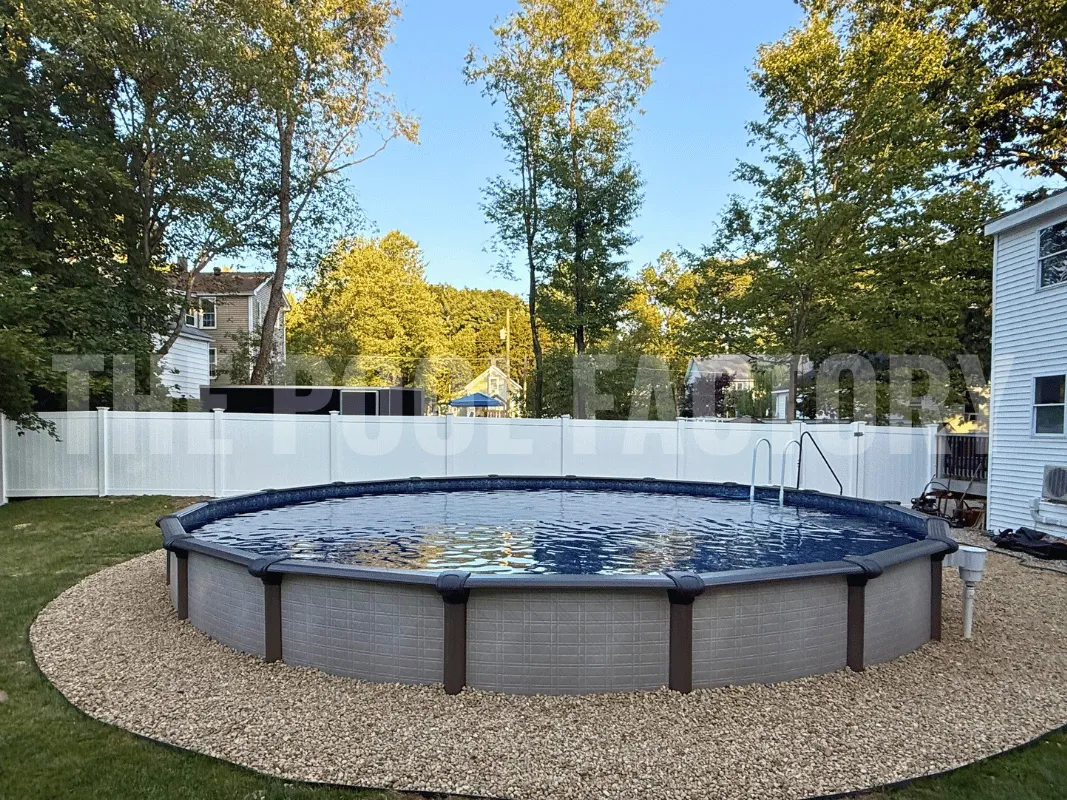 Round above ground pool surrounded by decorative stones and green grass