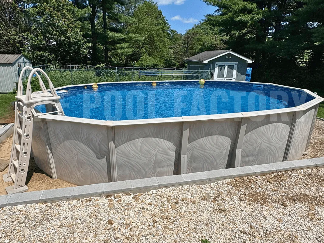 Oval above ground pool with a-frame safety ladder and stone retaining wall