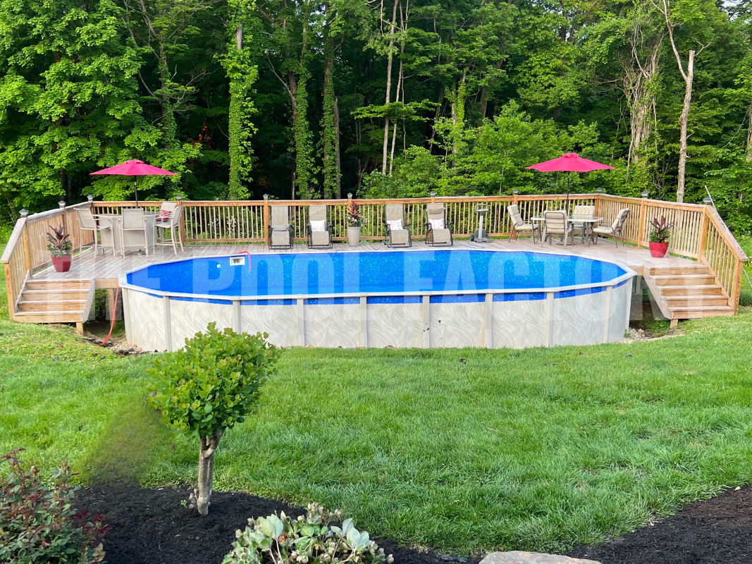 Oval above ground pool surrounded by a large wooden deck and comfortable lounge seating