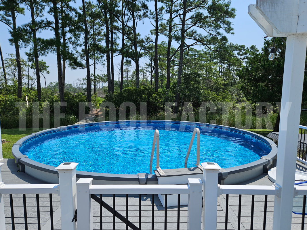 Above ground saltwater swimming pool with partial deck surrounded by tall trees