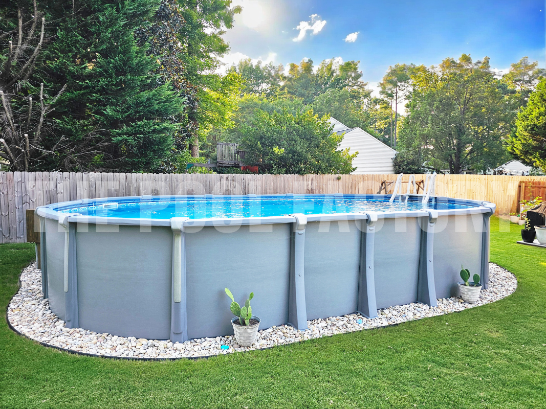 Oval saltwater swimming pools with decorative rocks and wooden privacy fence