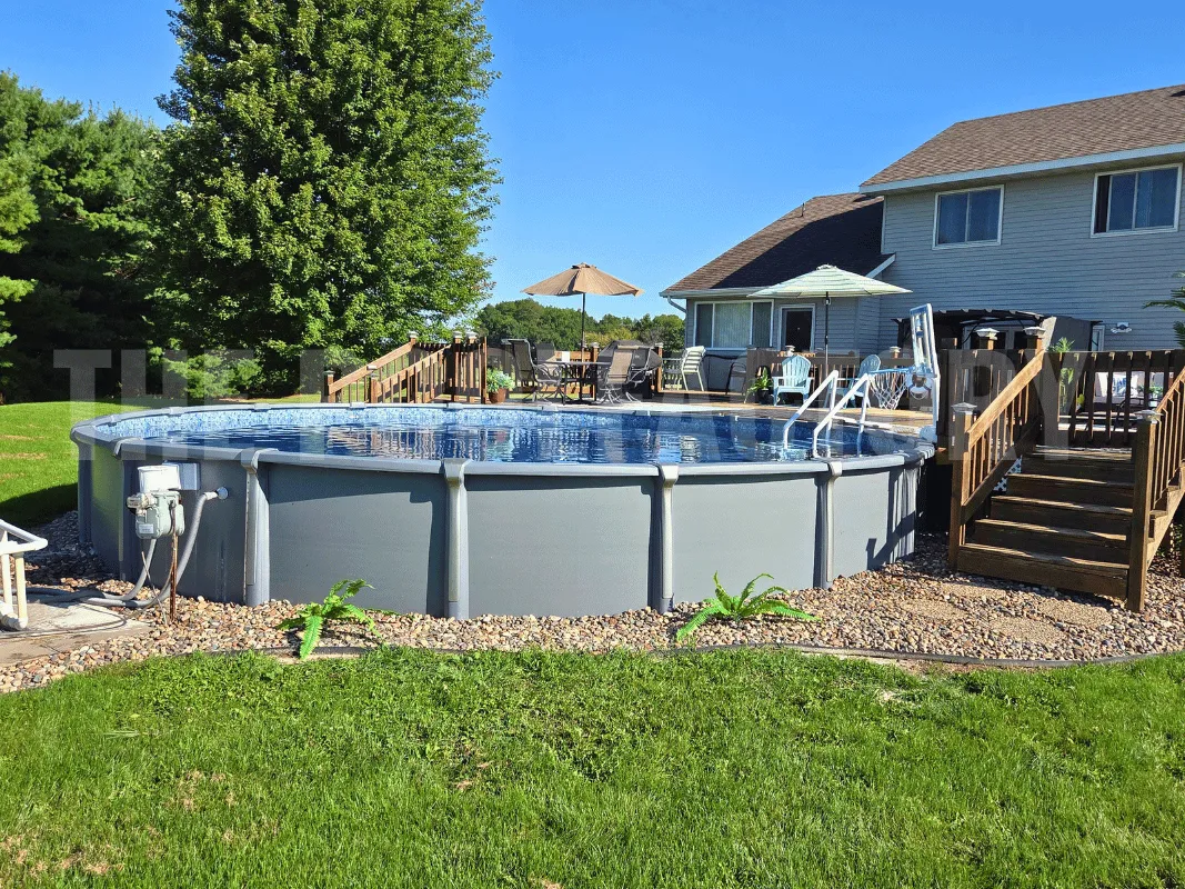 Premium saltwater semi-inground pool with wooden deck, lounge chairs, and umbrella