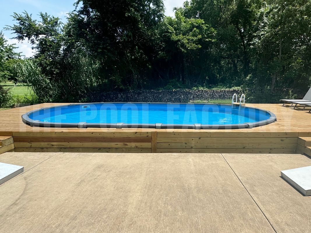 Oval saltwater pool with full deck, concrete patio and lounge chairs