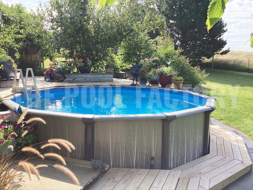 Round above ground swimming pool with deck pathway, decorative plants and greenery surrounding