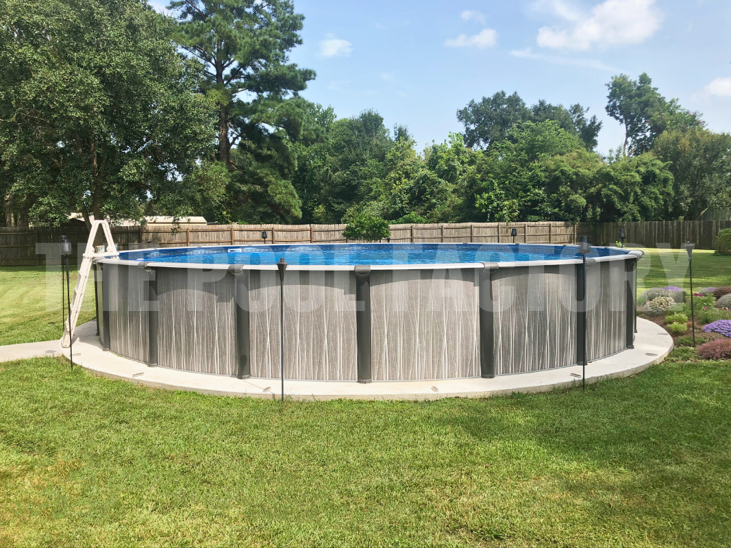 Round above ground swimming pool surrounded by concrete pathway and a wood privacy fence 
